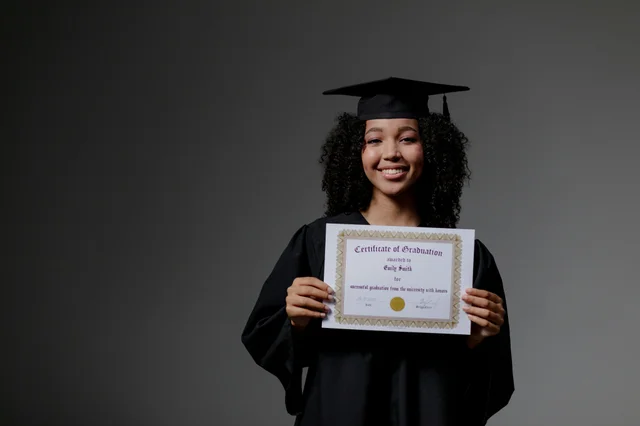 Smiling graduate holding a certificate in cap and gown