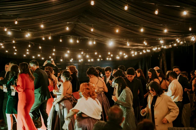 Guests enjoying an elegant evening reception under string lights