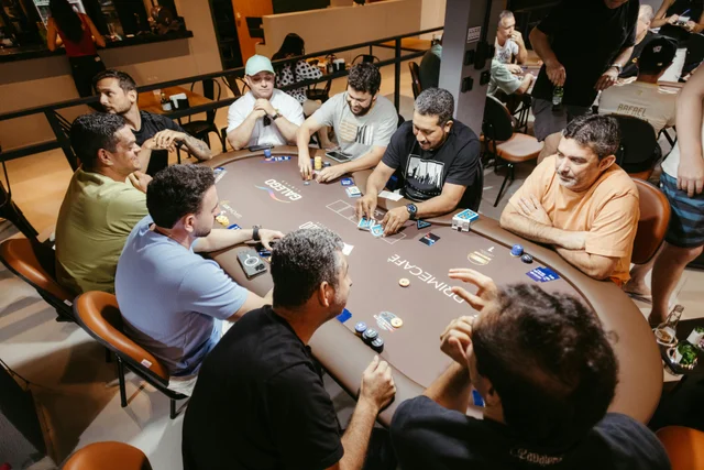 Group of men engaged in a poker game at an indoor setting